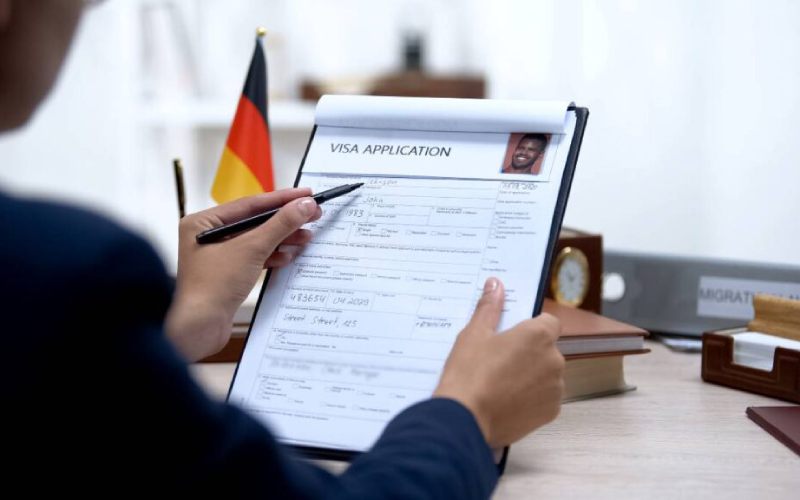 Un homme remplissant un papier administratif pour obtenir son visa.