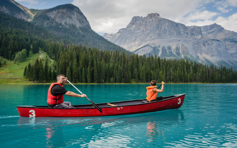 Un homme et son fils faisant du kayak sur un lac au Canada.